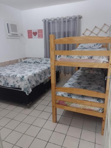 a bedroom with two bunk beds and a bed at Condomínio Mar de Búzios in Nísia Floresta