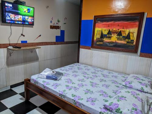 a room with a bed and a tv in it at Pousada Aguiar in Rio Preto Da Eva