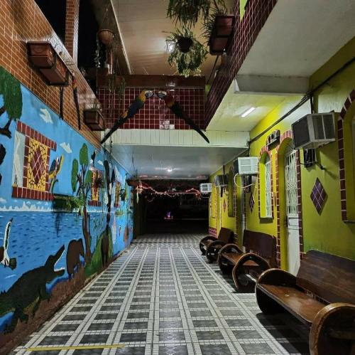 a hallway with benches and a mural on the wall at Pousada Aguiar in Rio Preto Da Eva