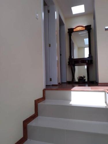 a hallway with stairs and a mirror in a room at Casa, Hospedaje Turístico. in Otavalo