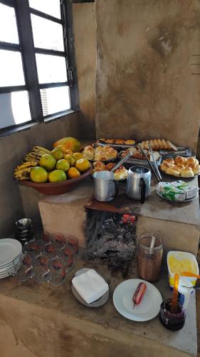Pousada Recanto Alaketu Hospedagens في كامبو غراندي: مطبخ مع مجموعة من الطعام على طاولة
