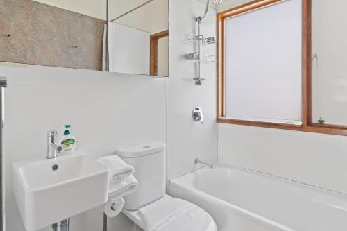 a white bathroom with a sink and a toilet at Moongalba in Point Lookout