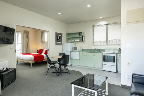 eine Küche und ein Wohnzimmer mit einem Bett und einem Tisch in der Unterkunft Jasmine Court Motel in Picton