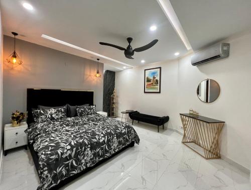 a bedroom with a bed and a ceiling fan at Chic Noir 1 Bedroom Apartment Gulberg in Lahore