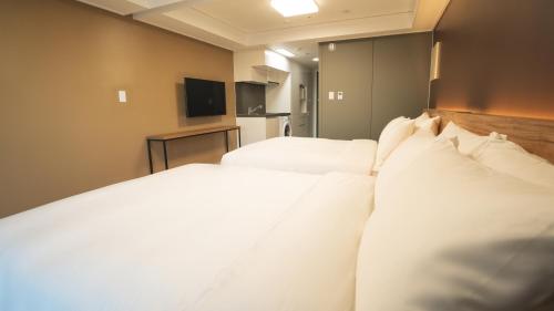 two beds in a hotel room with white pillows at Marinabay Sokcho in Sokcho