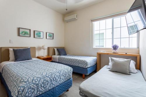 a bedroom with two beds and a window at Casa Balam-Exclusivo y Amplio-Ideal Home Office in Playa del Carmen