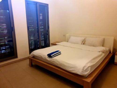 Flat Luxury 2 bed rooms apartment talabay aqaba في العقبة: سرير بحذاء يجلس عليه