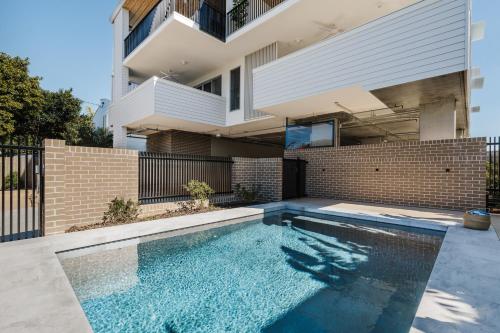 a swimming pool in front of a house at SILK - Lustrous Vacation Awaits 400m to the Beach in Coolum Beach