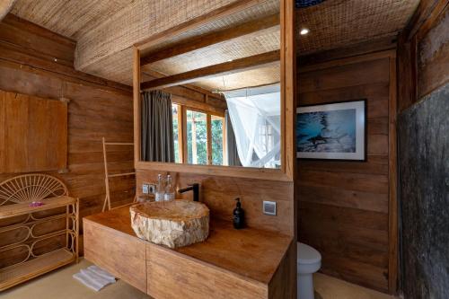 a bathroom with a large wooden sink and a toilet at Morin Resort in Nusa Lembongan