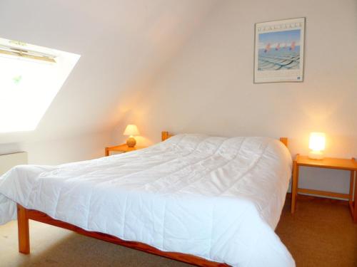 een slaapkamer met een wit bed en 2 tafels bij Appartement Cabourg, 2 pièces, 2 personnes - FR-1-794-15 in Cabourg