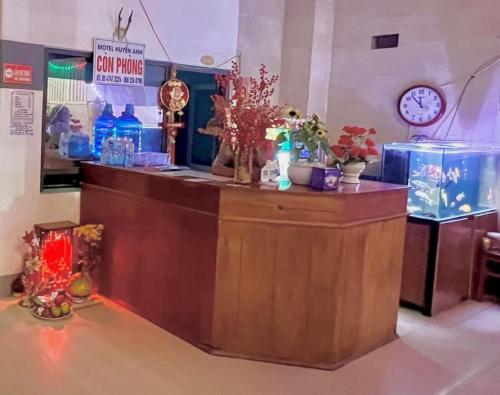 a counter in a store with flowers and a clock at Huyền Anh Motel Cam Ranh in Cam Ranh