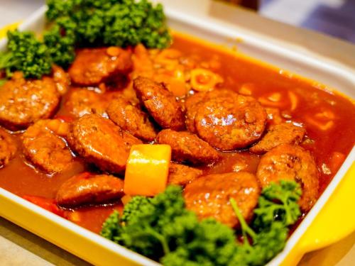 a tray of food with meat and broccoli in it at Hotel AreaOne Sakaiminato Marina in Sakaiminato