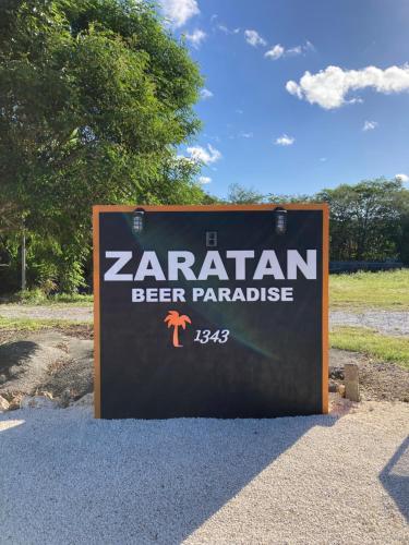 a sign for a beer park with the words zaria beer paradise at ZARATAN in Motobu