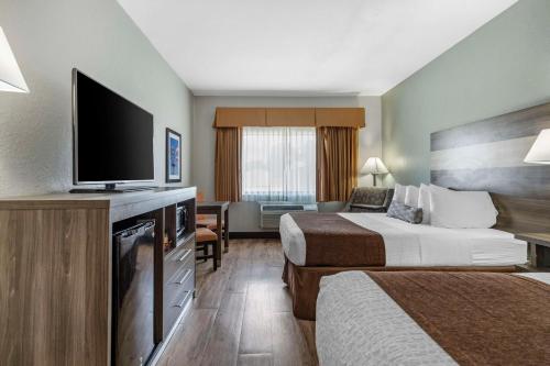 Best Western PLUS Victoria Inn & Suites في فيكتوريا: غرفة فندقية بسريرين وتلفزيون بشاشة مسطحة