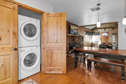 a laundry room with a washer and dryer next to a table at Villa Grove by Rather Be Properties in Big Bear Lake