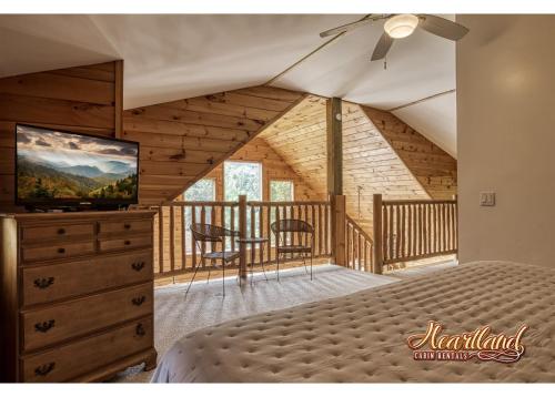 a bedroom with a bed and a television in a cabin at Honeymoon Cabin with Great Mountain View and Hot Tub in Gatlinburg