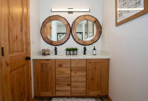 a bathroom with a sink and two mirrors on the wall at Villa Grove by Rather Be Properties in Big Bear Lake