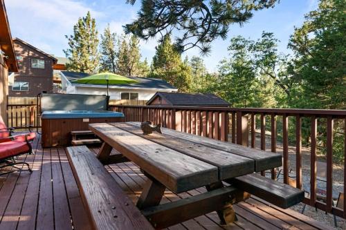 a wooden picnic table on a deck with a grill at Villa Grove by Rather Be Properties in Big Bear Lake