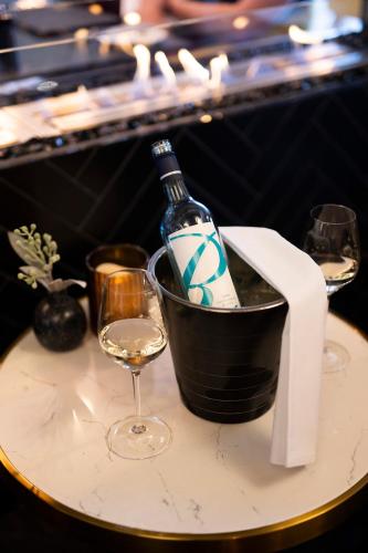 a bottle of wine in a bucket on a table with a glass at The Remington Orange in Orange