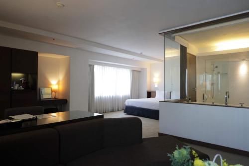a hotel room with a bed and a large mirror at United Hotel in Taipei