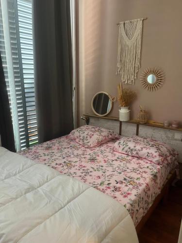 een slaapkamer met een bed, een spiegel en een raam bij P’tit Cosy St Denis - centre in Saint-Denis