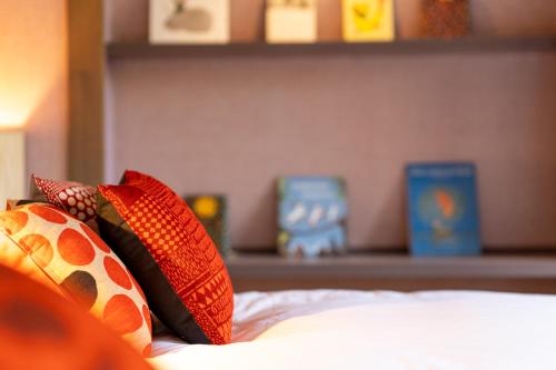 a bed with colorful pillows on top of it at Enokiya Ryokan in Yufuin