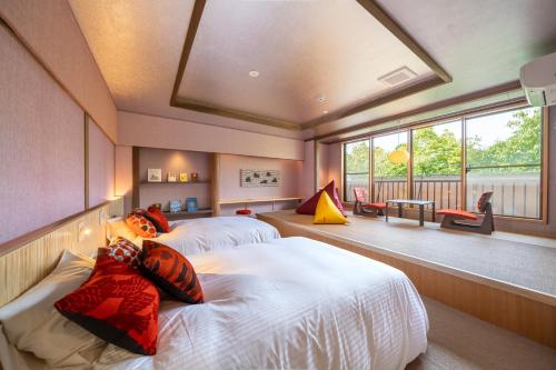 由布市にある榎屋旅館の大きな窓付きの客室で、ベッド2台が備わります。