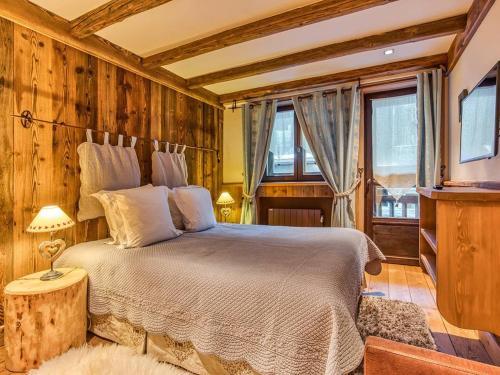 ein Schlafzimmer mit einem Bett in einem Zimmer mit Holzwänden in der Unterkunft Appartement 112m² Courchevel 1850, centre, proche pistes, 3 chambres, balnéo, hammam, WIFI - FR-1-631-165 in Courchevel