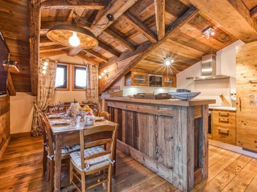 d'une salle à manger avec une table et d'une cuisine avec des plafonds en bois. dans l'établissement Appartement de Charme à Courchevel 1850 - 4 pers, Centre, Proche des Pistes, Balcon et Hammam - FR-1-631-163, à Courchevel