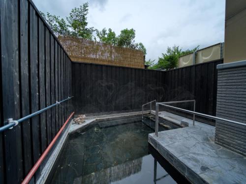ein Pool vor einem Zaun in der Unterkunft Enokiya Ryokan in Yufu