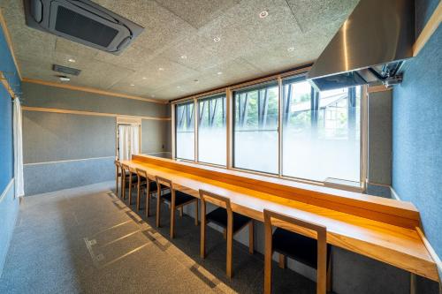 a room with a row of tables and chairs at Enokiya Ryokan in Yufuin
