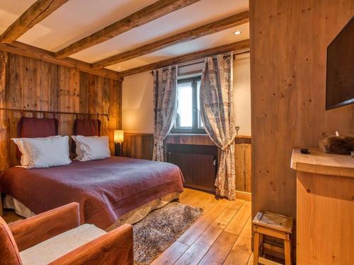 une chambre avec un lit dans une pièce aux murs en bois dans l'établissement Cosy et Spacieux 105m² à Courchevel 1850 - 6 Pers - Centre Station, Proche Pistes, Confort & Équipements - FR-1-631-162, à Courchevel