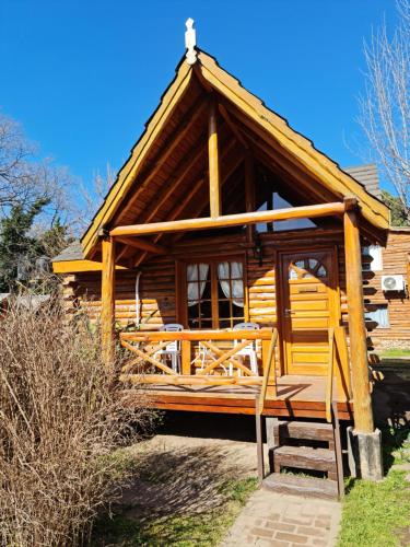 a wooden cabin with a porch and a roof at Cabañas La Ponderosa in Villa Ventana