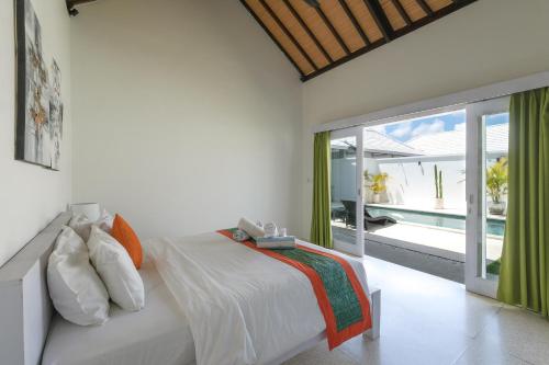a bedroom with a bed and a sliding glass door at Villa Shanti Bingin in Uluwatu