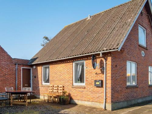 a red brick house with a table and a table at 8 person holiday home in Lemvig-By Traum in Lemvig
