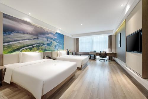 a hotel room with two beds and a flat screen tv at Atour Hotel Nanning Nanhu Subway Station in Nanning