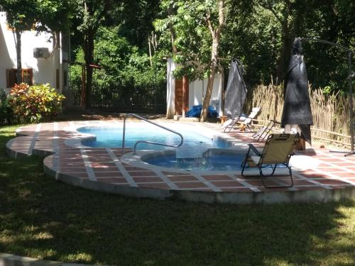 uma piscina num quintal com duas cadeiras ao lado em Nueva Tierra em Las Tunas