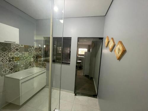 a bathroom with a glass shower and a sink at Casa aconchego Luís Eduardo Magalhães in Luís Eduardo Magalhães