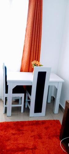 mesa de comedor blanca con alfombra roja en Comfort Inn, en Kisumu