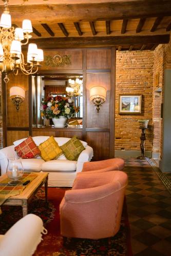 a living room with a white couch and chairs at Villa Delia Hotel and Cooking School in Ripoli