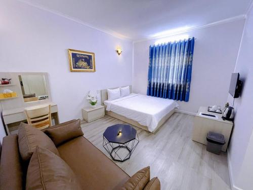 ein Wohnzimmer mit einem Sofa und einem Bett in der Unterkunft Sai Gon Ha Tien Hotel in Hà Tiên