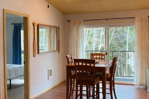 a dining room with a table and chairs and a window at Hammersley Inlet- Oyster beach apt, Relaxing Views in Shelton