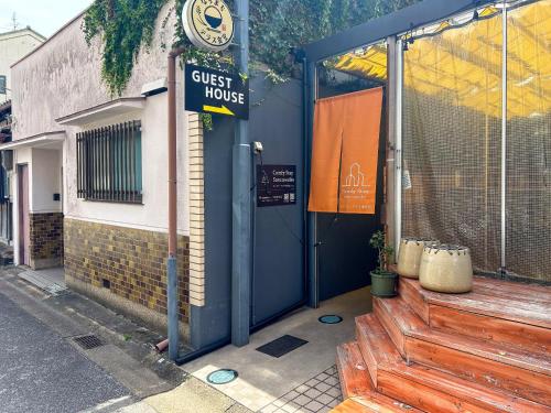un edificio con un cartello che legge la guest house di Comfy Stay Sarusawaike a Nara