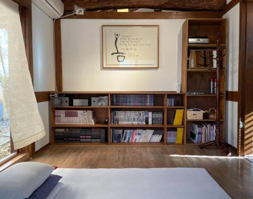 un dormitorio con una estantería llena de libros en Inner-Stay, en Tongyeong