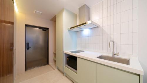 a white kitchen with a sink and a stove at Stone Island Pool Villa in Yeosu