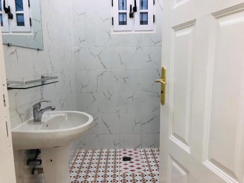 Un baño blanco con lavabo e inodoro. en villa piscine orchidée, en Pointe-Noire