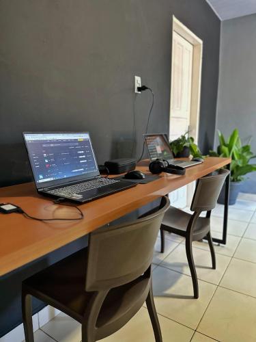 a desk with a laptop computer on top of it at Hostel Native in Boa Vista