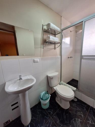 a bathroom with a sink and a toilet and a shower at Chaska valle Inn in Urubamba