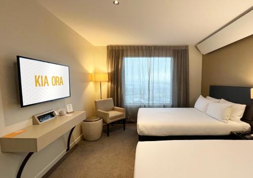 a hotel room with a king sized bed and a tv at Sudima Auckland Airport in Auckland