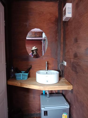 ein Bad mit einem Waschbecken und einem Spiegel in der Unterkunft บ้านทุ่งโฮมสเตย์ in Ban Chai Khlong
